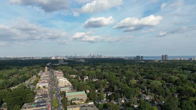 Aerial view over Bloor Street West in the Kingsway neighborhood of Toronto, Ontario, Canada. Flying southeast towards the downtown core Toronto skyline, Mimico and Lake Ontario.