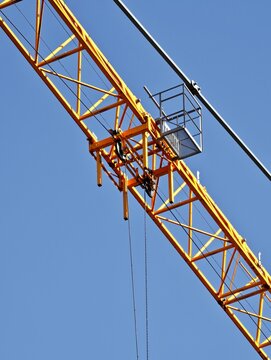 Detail of yellow construction crane jib with trolley and pulleys