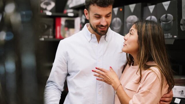 Happy couple choosing kitchenware together in a store