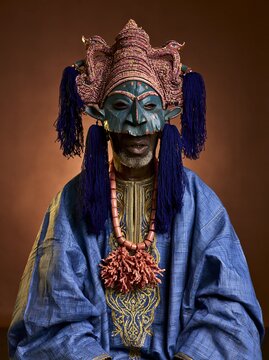 A Yoruba elder wearing a Gelede painted wooden mask with elaborate headdress