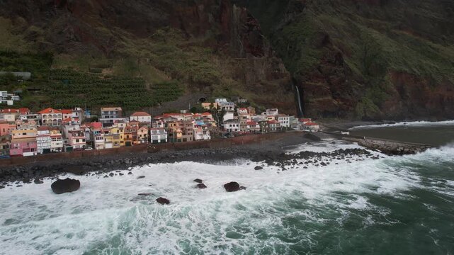 Aerial perspective of the Atlantic Ocean waves crashing on the coastline of Paul do Mar, a picturesque fishing village nestled in Madeira