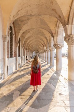 Young woman in the portico at the Doge's Palace, St. Mark's Square, Venice, Veneto, Italy
