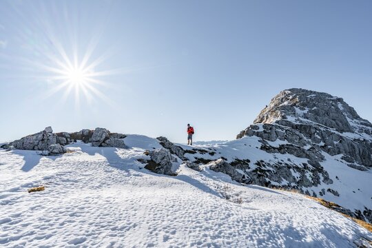 Climbers on the rocky summit ridge with first snow in autumn, hiking trail to Guffert, solar reflex, Brandenberg Alps, Tyrol, Austria