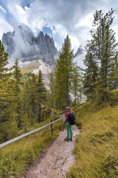 Young woman, hiker on a hiking trail, in the back Sass Rigais, Parco Naturale Puez Odle, South Tyrol, Italy