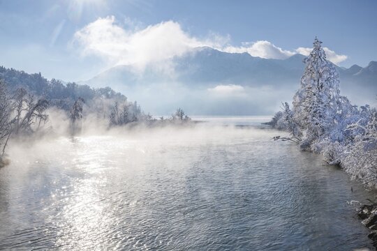Winter landscape with outflow of the Loisach from the Lake Kochel in front of the Herzogstand 1731m, Kochel am See, Das Blaue Land, Bavarian Alps, Upper Bavaria. Bavaria, Germany