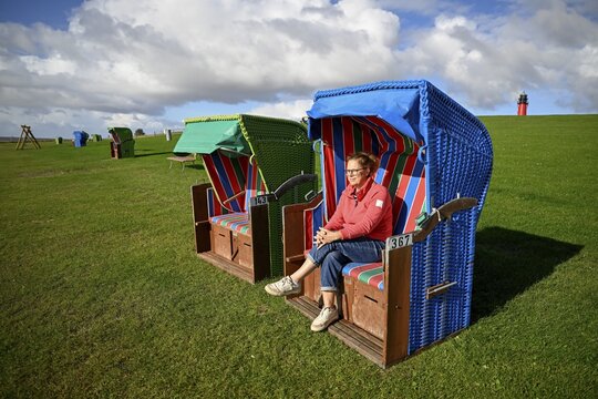 Woman in a beach chair on the island of Pellworm, Wadden Sea National Park, North Frisia, Germany