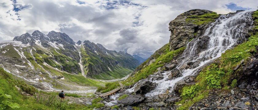 Panorama, green mountain valley Floitengrund with mountain stream Floitenbach, mountaineer on a hiking trail, waterfall on a mountain slope, ascent to Greizer H&uuml;tte, Berliner H&ouml;henweg, Zillertal Alps, Tyrol, Austria