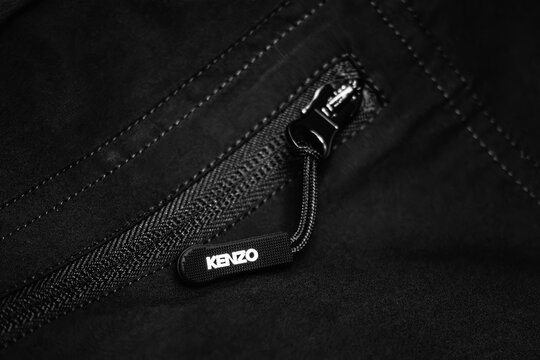 Nice, France - March 1, 2026: Close-up of a Kenzo branded zipper pull and black technical fabric, highlighting garment construction, hardware details and signature fashion branding
