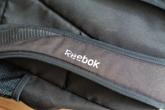 Warsaw, Poland - Jan 11, 2026: Close-up of black fabric texture with visible Reebok logo, showcasing sportswear material design and urban lifestyle branding.