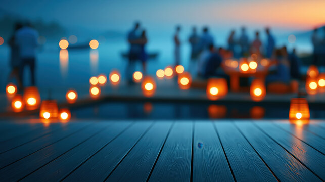 Blurred lakeside summer gathering with warm lantern light and silhouettes near wooden deck at dusk, serene evening scene