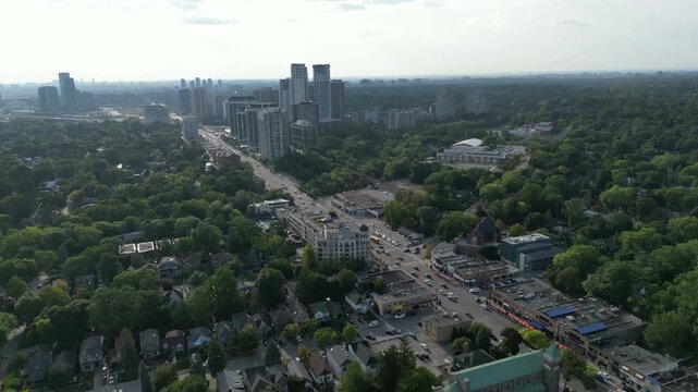 Aerial view over Bloor Street West in the Kingsway neighborhood of Toronto, Ontario, Canada. Flying northwest towards the skyline of high-rises around Islington Station and Islington City-Centre West.