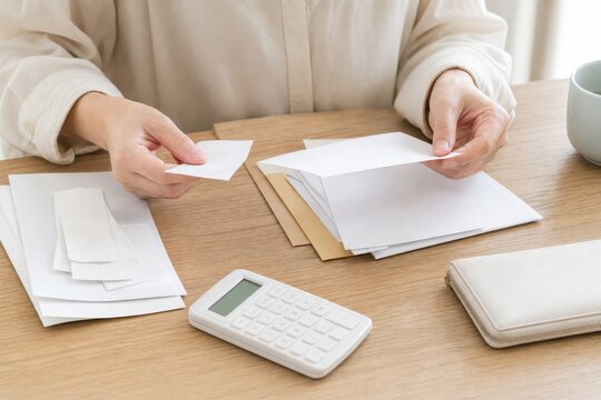 家計簿と電卓で生活費を確認する手元