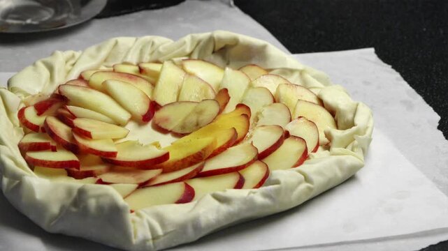 Arranging fresh nectarine slices into geometric pattern on pie dough