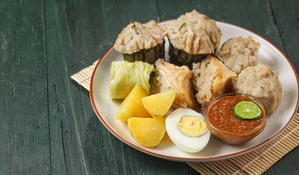 Siomay Bandung. Fish cake dumplings with potato, egg, and cabbage roll served with peanut, chili, sweet soy sauces and lime