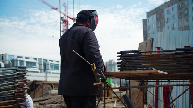 Welder working with steel reinforcement at construction site