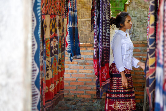 Indonesian Woman Exploring Traditional Tenun Ikat Textiles