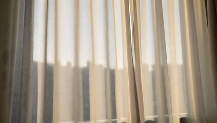 Obraz premium Sheer Curtains in Soft Light: Delicate, sheer curtains diffuse the natural light, casting a gentle, warm glow and creating a serene ambiance in an interior space.