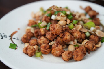 Fototapeta premium Crispy deep fried squid mouths with peanuts and scallions.