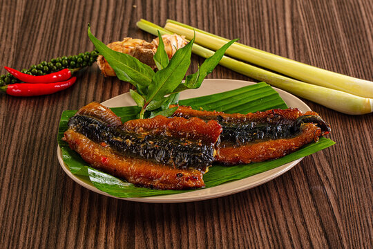 Grilled snakehead fish served on banana leaf with herbs