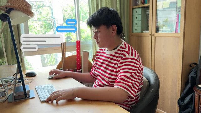4K footage of a young Asian teen boy sitting at his home desk, using a desktop computer with floating educational chat bubble graphics.