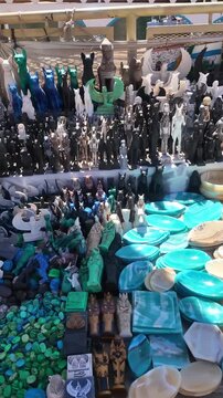 Colorful stall displaying traditional egyptian crafts for tourists at philae market. Souvenirs include stone statuettes, figurines and bowls