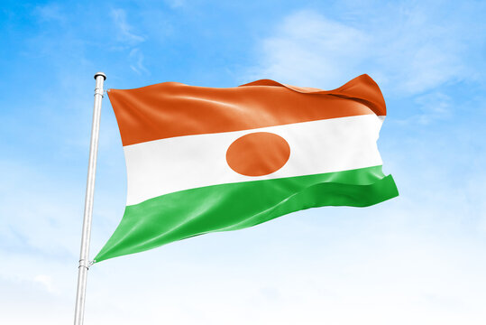 Niger national flag waving against blue sky