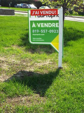 Gatineau, Quebec, Canada &ndash; May 12, 2026: A green DuProprio "J'ai Vendu" real estate sign stands in a grassy area on Boulevard de la Cit&eacute;-des-Jeunes.