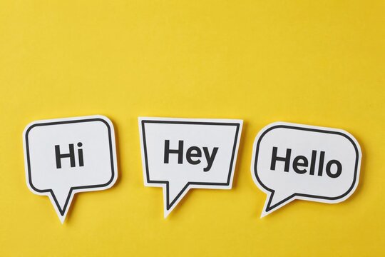 Three white speech bubbles with hi, hey, and hello text on yellow background
