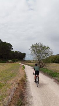 Aerial shot of cyclist on countryside dirt road
