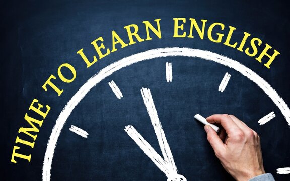 Time to learn english text written in chalk on a blackboard clock face