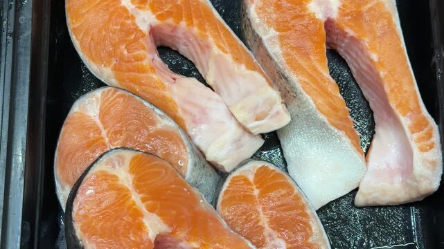 Chilled chum salmon steaks from frozen raw materials on a substrate for sale in a supermarket. Close-up