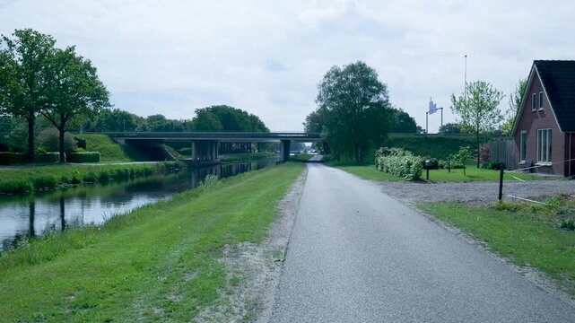 Scenic paved path running along a river canal in the netherlands
