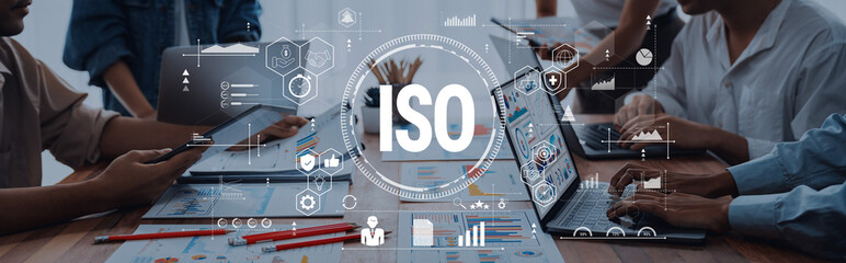 Professionals collaborate in a modern office, discussing ISO standards while analyzing data on...