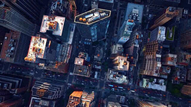 Overhead look at metropolitan streets, New York City. Straight down vertical composition showing long shadows, yellow cabs and building rooftops.