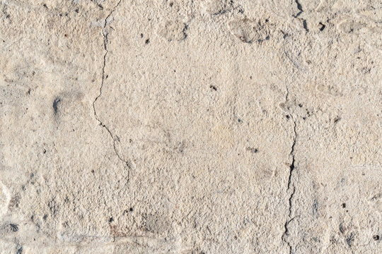 Macro horizontal closeup of bumpy weathered concrete surface with vertical cracks copy space background template