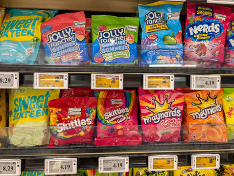 Quebec, Canada, 25 April 2026 : Bags of assorted candy and gummies from brands including Jolly Rancher, Nerds, and Skittles on store shelves.