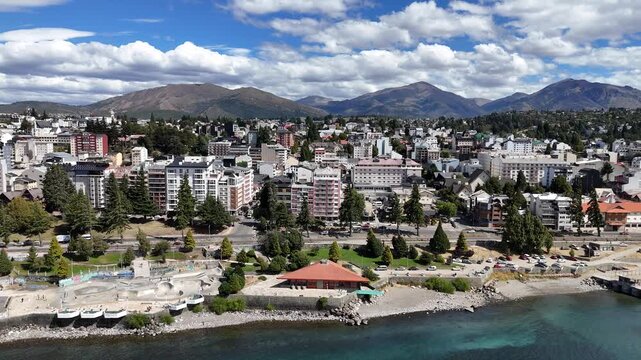 Cinematic aerial footage of the alpine city of San Carlos de Bariloche on the shores of Nahuel Huapi Lake, Patagonia, Argentina. A beautiful mountain town skyline.