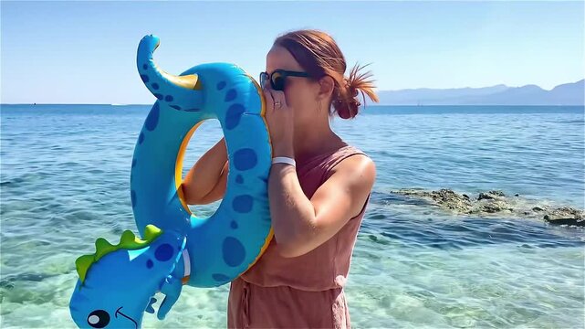 Woman inflating swim ring at sea beach.mom preparing float ring for children swimming.Summer family travel vacation,healthy outdoor activity,water sport.Water toy