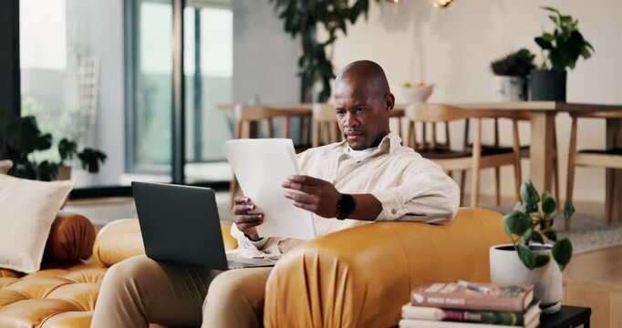Laptop, remote work and paperwork with black man on sofa in living room for small business in home. Tech, document and report with freelancer in apartment for startup research, proposal or review