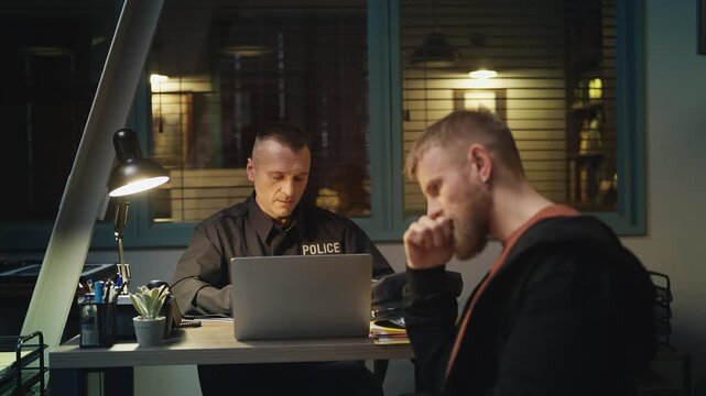 Middle-aged police detective questioning a male witness during an investigation