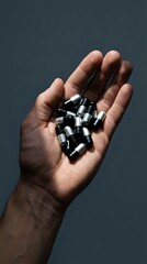 Fototapeta premium Male hand holding ammunition bullets against neutral background, suitable for security, law enforcement, and editorial content.