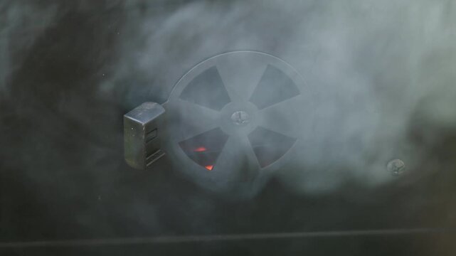Close-Up of Smoke Escaping from BBQ Grill Air Vent with Glowing Embers