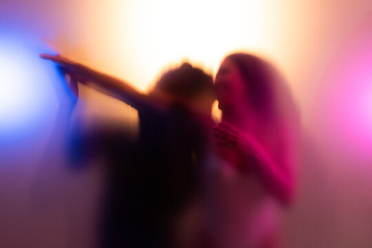 Man kissing his couple body behind frost glass in warm light while making love together