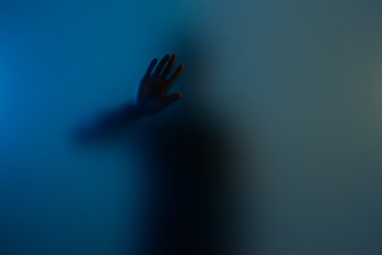 Anonymous man touching frosted glass with one hand. Help seeking and hope concept
