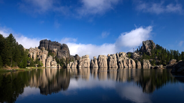 Sylvan Lake South Dakota granite formations reflected in calm water under blue sky