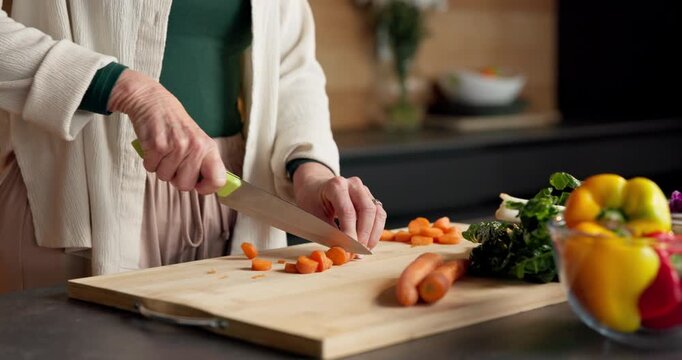 Cutting, hands and vegetables with person in kitchen of home for healthy meal preparation. Cooking, food and knife with senior woman at counter in apartment for cuisine, culinary hobby or recipe