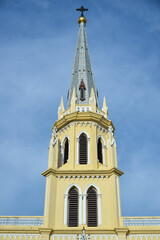 Obraz premium Bangkok, Thailand – May 14, 2026: Gothic Revival spire and bell tower of Holy Rosary Church (Kalawar Church) against a dramatic sky in Bangkok