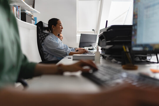 Employees working at computers in a modern office environment. Productivity, teamwork, technology and everyday business operations concept