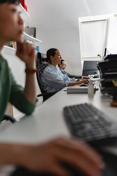 Professional woman concentrating on computer tasks in office environment. Focus, efficiency, technology and workplace productivity concept