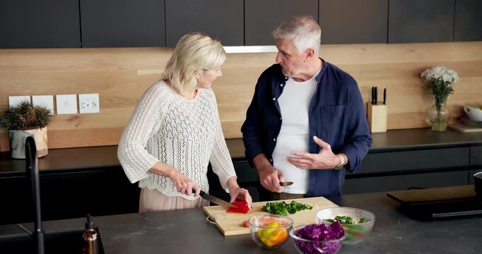 Talking, home and old couple with vegetables, cooking and healthy with knife, recipe and cutting. Support, advice and senior people in kitchen, skills and ingredients with meal prep and discussion